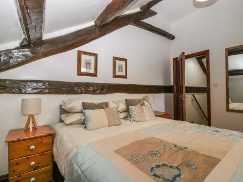 1 dormitorio con 1 cama grande y techo de madera en Cherry Tree Barn en Ulverston