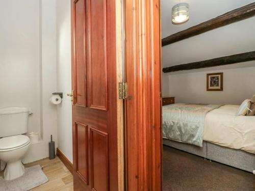 a bathroom with a toilet and a bed at Cherry Tree Barn in Ulverston