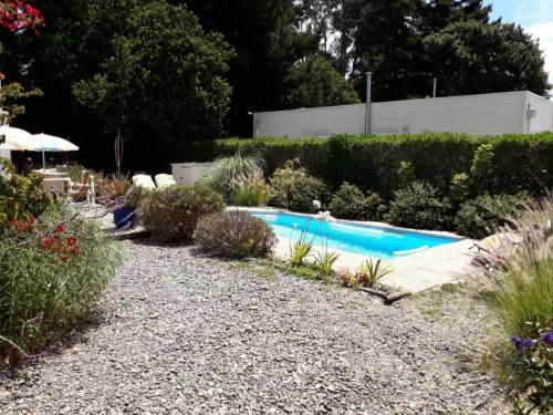 una piscina en un jardín con flores y plantas en Casa en Papudo, en Petorca