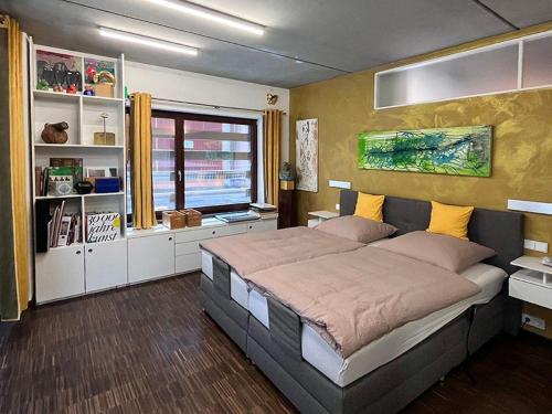 - une chambre avec un grand lit et une fenêtre dans l'établissement GALERIE-SUITE-11, à Marktheidenfeld