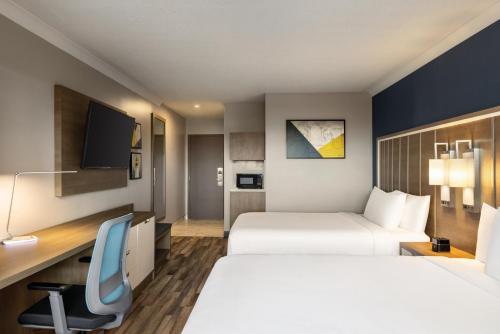 a hotel room with two beds and a desk at Crowne Plaza Saint John Harbour View by IHG in Saint John