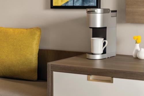 a coffee machine on a table with a yellow pillow at Crowne Plaza Saint John Harbour View by IHG in Saint John