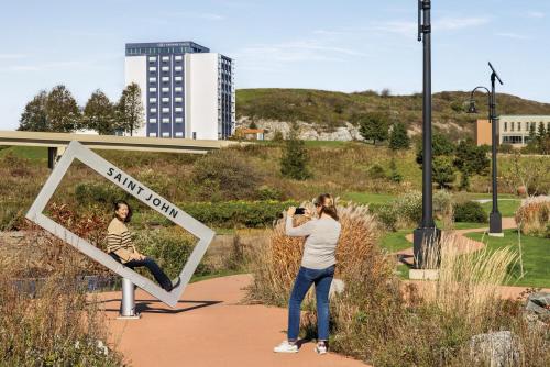 a woman taking a picture of a man in a mirror at Crowne Plaza Saint John Harbour View by IHG in Saint John