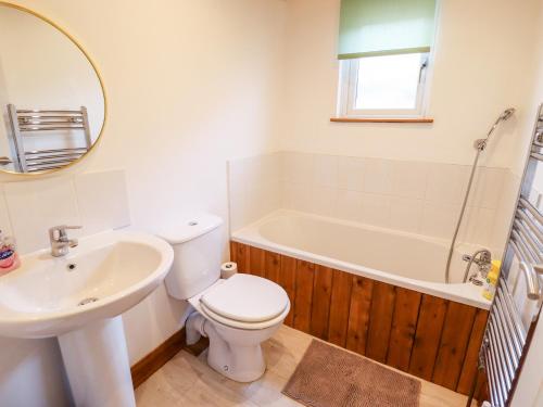 a bathroom with a toilet and a sink and a tub at Kantankye Lodge in Skegness