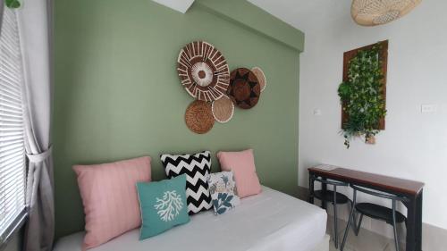 una camera con divano, cuscini e tavolo di Comfy 2 Bedroom Apartmen Pavilion Permata Surabaya a Dukuhpakis