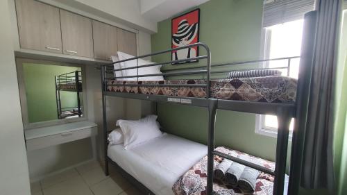 a bedroom with two bunk beds with a small bed at Comfy 2 Bedroom Apartmen Pavilion Permata Surabaya in Dukuhpakis
