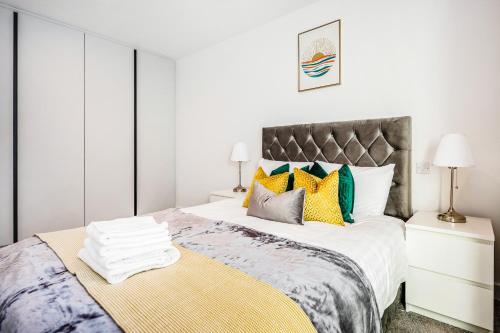ein Schlafzimmer mit einem großen Bett mit bunten Kissen in der Unterkunft New Riverside Apt sleeps 5 Easy to tour London in London