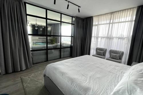 a bedroom with a bed and a large window at Lujoso penthouse con vista panoramica in Quito