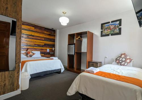 Habitación de hotel con 2 camas y TV en Hotel Plaza Central, en Ayacucho