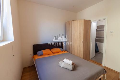a bedroom with a bed with two towels on it at Townhouse - WHITE CITY Apartments in Belgrade