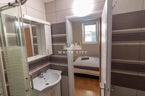 a bathroom with a sink and a toilet and a bed at Townhouse - WHITE CITY Apartments in Belgrade