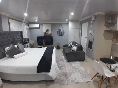 een slaapkamer met een groot bed en een woonkamer bij 54 Malcolm Palace Room in Durban