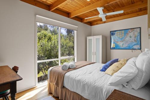 ein Schlafzimmer mit einem Bett und einem großen Fenster in der Unterkunft Just Beachy in Blairgowrie