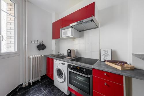 - une cuisine avec des placards rouges et un lave-linge dans l'établissement Nouveau T2 à 7 min de Saint-Lazare, à Asnières-sur-Seine