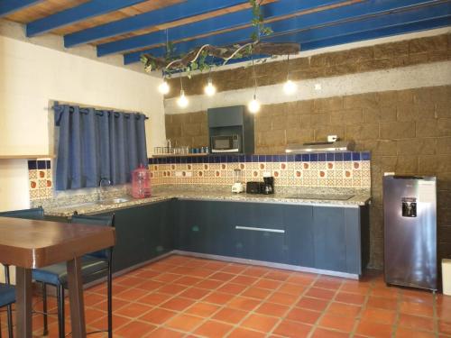 a large kitchen with a counter and a refrigerator at LONGO VI in San Antonio de las Alzanas