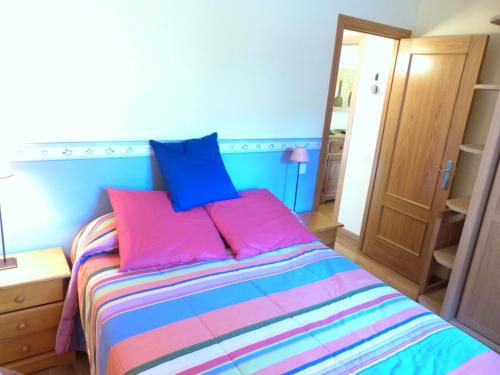 a bedroom with a bed with pink and blue pillows at Francoli-Vacances Pirinenca in Canillo