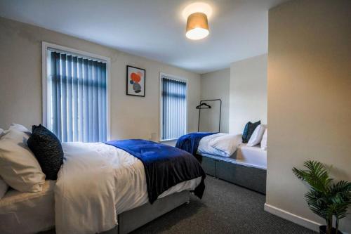 a bedroom with two beds and a couch in it at Sleeps 7 guests, great location in Liverpool