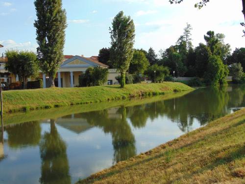 un fiume di fronte a una casa con alberi di B&B Casa Vally a Dolo