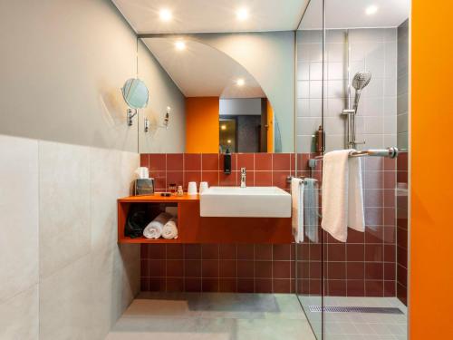 ein Bad mit einem Waschbecken und einem Spiegel in der Unterkunft ibis Styles St Margrethen Bodensee in St. Margrethen