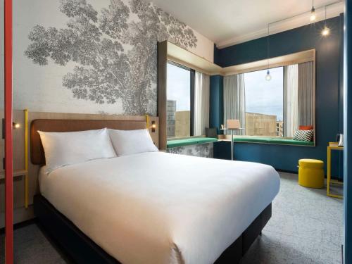 a bedroom with a large bed and a large window at ibis Styles Copenhagen Orestad in Copenhagen