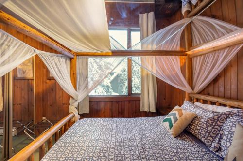 een slaapkamer met een hemelbed en een raam bij Darwin's in Girdwood