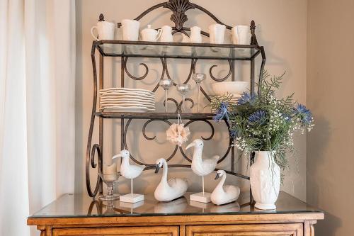 a shelf with ducks and vases on a table at Breathtaking Lake View With Spa Chalet 360 in Chertsey
