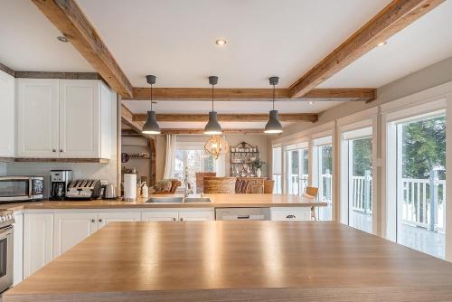 uma cozinha com armários brancos e um balcão de madeira em Breathtaking Lake View With Spa Chalet 360 em Chertsey