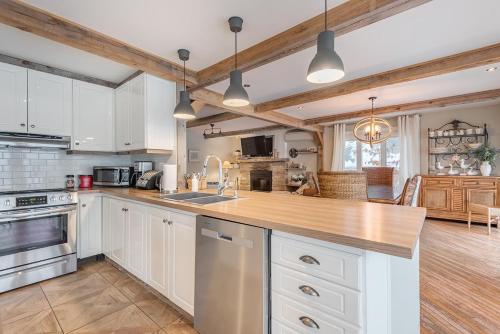 a kitchen with white cabinets and a wooden counter top at Breathtaking Lake View With Spa Chalet 360 in Chertsey