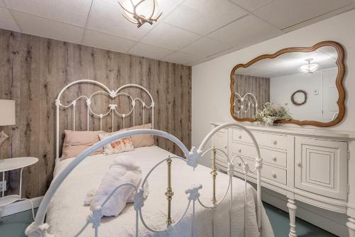 a bedroom with a white bed and a mirror at Breathtaking Lake View With Spa Chalet 360 in Chertsey