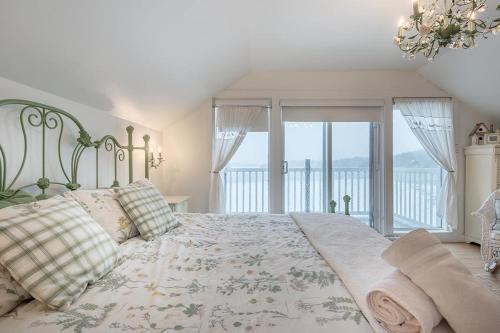 a bedroom with a large bed and a balcony at Breathtaking Lake View With Spa Chalet 360 in Chertsey