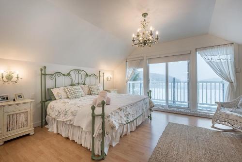 a bedroom with a bed and a large window at Breathtaking Lake View With Spa Chalet 360 in Chertsey