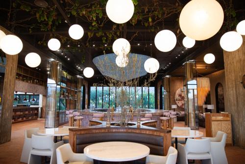 a restaurant with tables and chairs and a chandelier at Hotel Andana Winery & Spa in Valle de Guadalupe