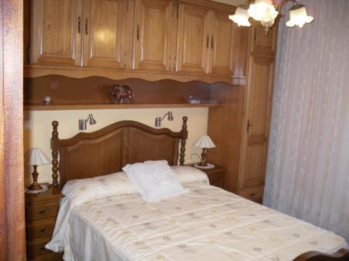 a bedroom with a large bed with wooden cabinets at Casa Rural Laguao in Abárzuza