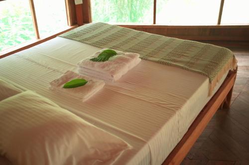 un letto con lenzuola bianche e asciugamani verdi di CHUNAKI ECOLODGES - Authentic Activities and Food in the Amazon a Zaragoza