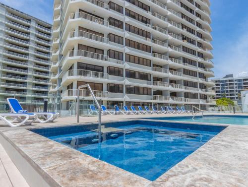 a pool in front of a large apartment building at Breakers North Absolute Beachfront Apartments in Gold Coast