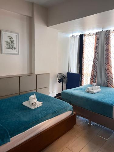 a hotel room with two beds and a chair at Mactan Newtown Rental by EJB in Punta Engaño