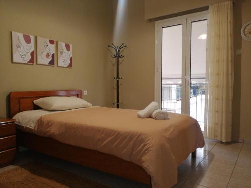 a bedroom with a bed and a sliding glass door at Central Home in Kalamata