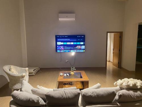 a living room with a couch and a tv at La Escondida Samber in San Bernardino