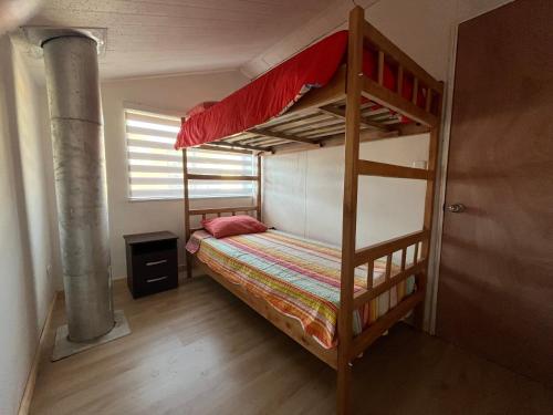 1 dormitorio con 2 literas y ventana en Casa Miramar, en Quellón