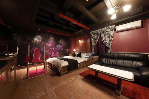 um quarto com uma cama e um sofá em M'SCLUB OsakaHirano AdultOnly em Osaka