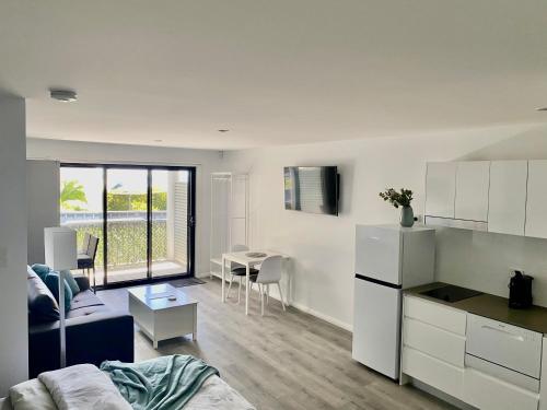 a kitchen and living room with a couch and a table at Shellharbour Haven in Shellharbour
