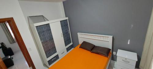a small room with an orange bed and a mirror at Apartamento 204 vista para o mar e piscina in Piúma