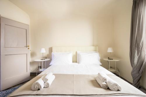 フィレンツェにある[Piazza Pitti]Luminoso Appartamento con Terrazzo e Parcheggio su richiestaのタオルが敷かれた白いベッドのある寝室