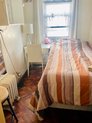 1 dormitorio con cama, escritorio y ventana en Prime Location- Central Manhattan, en Nueva York