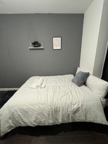 Ensuite room in West Midlands في Parkside: سرير بشرشف ووسائد بيضاء في غرفة النوم