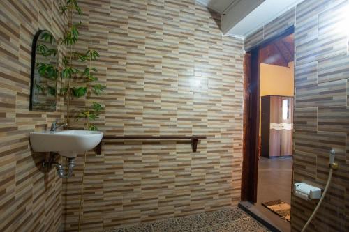 een badkamer met een wastafel en een bakstenen muur bij Fullmoon Bungalows in Toyapakeh