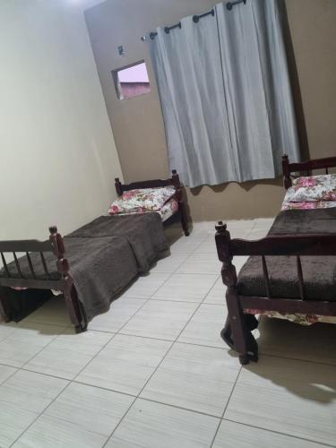 a room with two beds and a window at Cantinho da Vânia in Cabo Frio