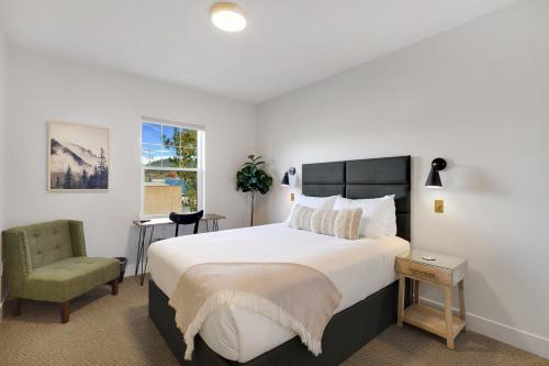 a bedroom with a large bed and a chair at Summit Lofts Boutique Hotel in Mount Shasta