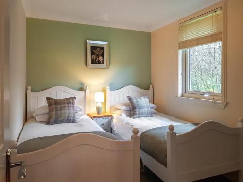 2 camas individuais num quarto com uma janela em Leven Lodge 2 - Uk46044 em Balloch