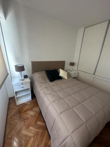 a bed in a room with two night stands and two lamps at CorrientesNice in Buenos Aires